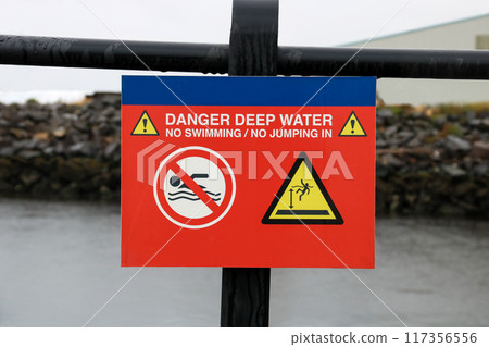 Danger Deep Water Signage at a Coastal Jetty on a Rainy Morning Danger Deep Water Signage at a Coastal Jetty on a Rainy Morning 117356556