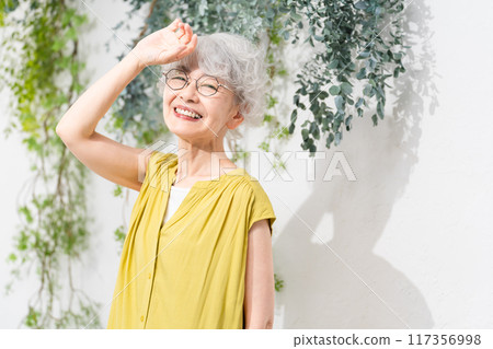 Senior woman wearing a yellow dress Senior woman wearing a yellow dress 117356998
