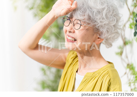 Senior woman wearing a yellow dress Senior woman wearing a yellow dress 117357000