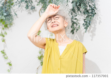 Senior woman wearing a yellow dress Senior woman wearing a yellow dress 117357001