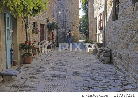 a man and a woman walk down a cobblestone sidewalk a man and a woman walk down a cobblestone sidewalk 117357231
