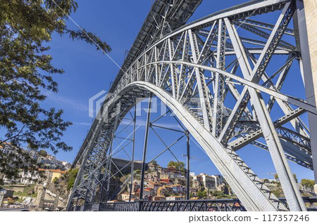 the arch of a bridge on a bright sunny day in porto, portugal 117357246