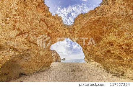 the cave is made from a piece of red rock by the ocean 117357294