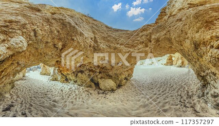 two large rocks sitting inside of a cave at the bottom of the desert two large rocks sitting inside of a cave at the bottom of the desert 117357297