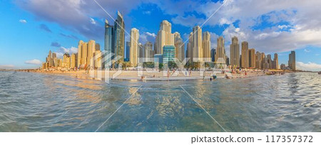 a city view with buildings across the water from a beach 117357372