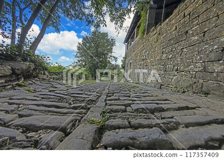this walkway is lined with cobbles and has a stone floor this walkway is lined with cobbles and has a stone floor 117357409