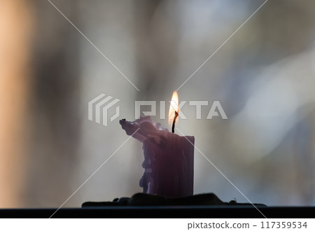 Burning candle on a table in a winter park. Shallow depth of field. Burning candle on a table in a winter park. Shallow depth of field. 117359534