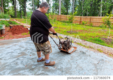 Vibration vibratory tamping machine compacts sand during construction of pool platform 117360074