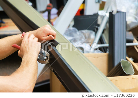 Aluminum rain gutters have been bent by machine tool then cut with shears to required size Aluminum rain gutters have been bent by machine tool then cut with shears to required size 117360226