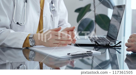 Doctor and patient consultation with clipboard and medication notes. Close-up view of unknown female doctor using a tablet during a patient consultation 117361505