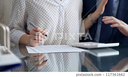 Businesspeople in a meeting with calculator. Sexual harassment is strictly prohibited in the workplace 117361662
