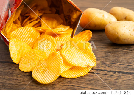 Potato chips fried snack fast food in open bag. 117361844
