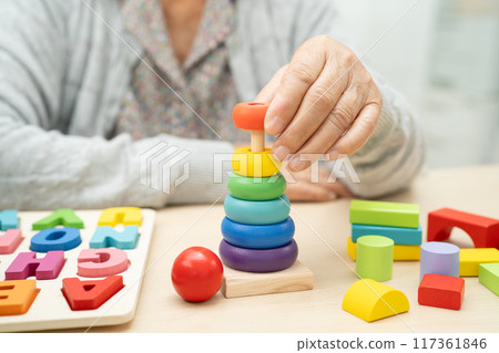 Alzheimer disease AD, Asian senior woman patient suffering from dementia learn practical motor skills rehabilitation. Alzheimer disease AD, Asian senior woman patient suffering from dementia learn practical motor skills rehabilitation. 117361846