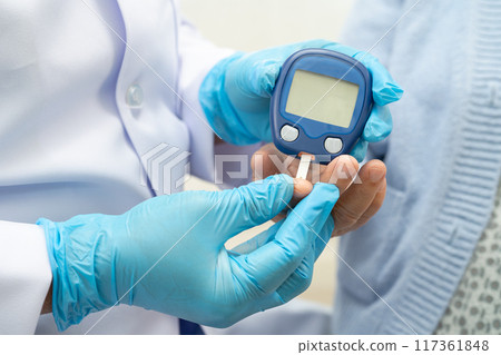 Doctor use digital glucose monitor measure and test stripe for check diabetes from finger blood sugar level. 117361848