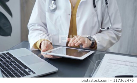 Doctor at work. Medical professional using tablet in clinic office. Medicine and health care concept 117362476