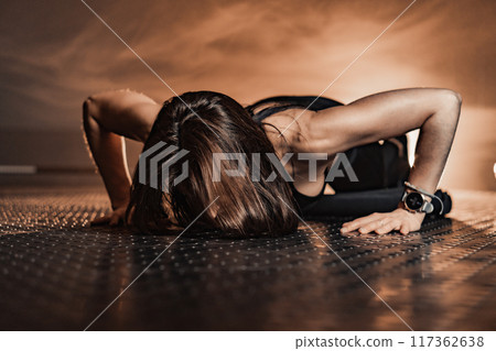 A dedicated female athlete confidently performs a series of pushups in a modern gym, showcasing her remarkable strength and intense focus within a vibrant, motivating atmosphere that inspires others 117362638