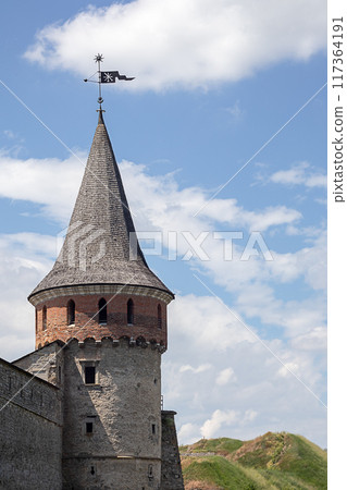 Tower of the Old Kamenets-Podolsk fortress against the background of the sky with clouds, Ukraine. Tower of the Old Kamenets-Podolsk fortress against the background of the sky with clouds, Ukraine. 117364191