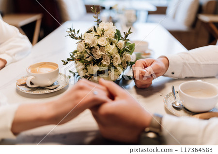 Romantic engagement moment, couple holding hands with rings, celebrating love and commitment Romantic engagement moment, couple holding hands with rings, celebrating love and commitment 117364583