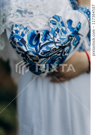 Close-up of traditional Ukrainian wedding attire with intricate blue embroidery, symbolizing cultural heritage Close-up of traditional Ukrainian wedding attire with intricate blue embroidery, symbolizing cultural heritage 117364587