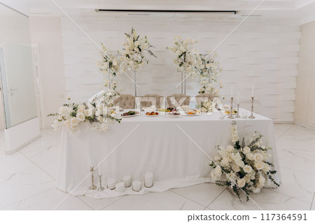 Elegant wedding reception setup with luxurious floral arrangements and chic table decor 117364591