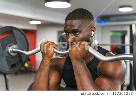 Black man training biceps with the Z-bar 117365238