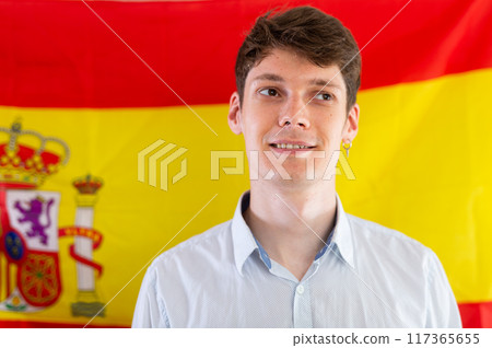 Young guy posing in front of flag of Spain Young guy posing in front of flag of Spain 117365655