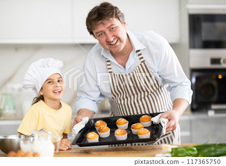 Father and daughter prepared muffins in kitchen Father and daughter prepared muffins in kitchen 117365750