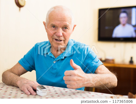 Happy senior man checking blood oxygen level with pulse oximeter Happy senior man checking blood oxygen level with pulse oximeter 117365806