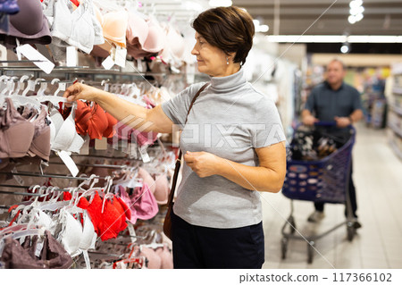Elderly woman chooses bra in store Elderly woman chooses bra in store 117366102