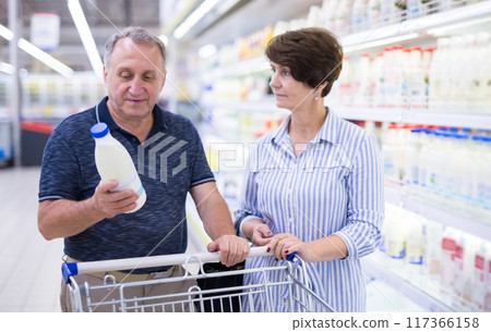 Mature couple husband and wife choose milk in supermarket 117366158