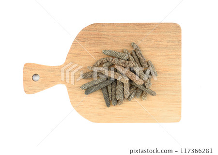 Top view of wooden cutting board with Long or Pippali pepper over white background. Top view of wooden cutting board with Long or Pippali pepper over white background. 117366281