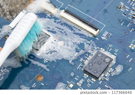 Top view. Technician cleaning motherboard. computer with cleaning solution 117366848