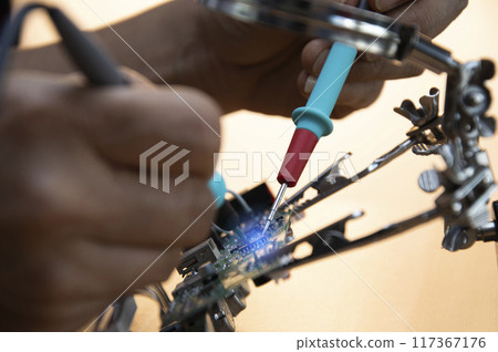 Technicians are repairing motherboards and checking electrical currents, repairing circuits 117367176
