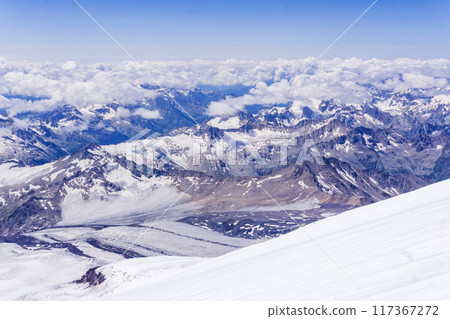 mountain landscape, view from highland glacier to mountain ranges in the clouds, view from the Mount Elbrus to the Main Caucasian Range 117367272