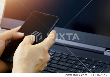 Business woman who is working and using a smartphone 117367347