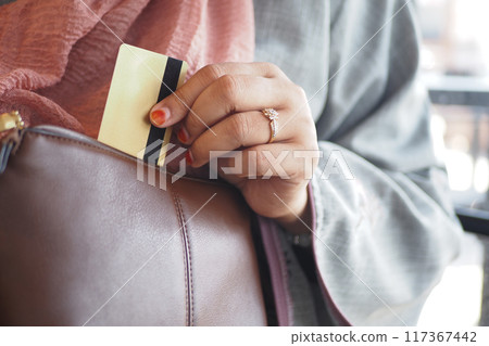 woman taking credit card out from her purse woman taking credit card out from her purse 117367442