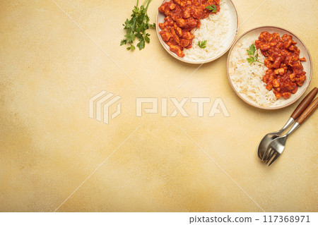 Indian chicken curry with rice and turmeric on yellow background with copy space top view Indian chicken curry with rice and turmeric on yellow background with copy space top view 117368971