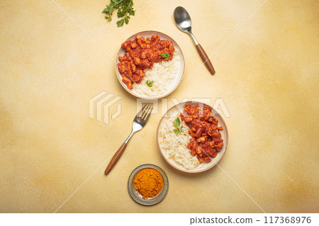 Indian chicken curry with rice and turmeric on yellow background with copy space top view Indian chicken curry with rice and turmeric on yellow background with copy space top view 117368976