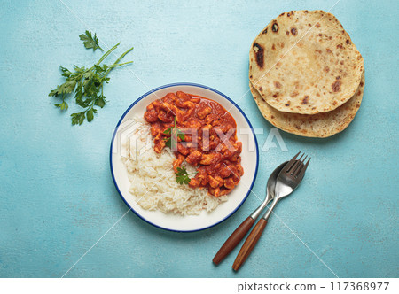 Indian chicken curry with basmati rice served on plate with chapati flatbread on the side top view Indian chicken curry with basmati rice served on plate with chapati flatbread on the side top view 117368977