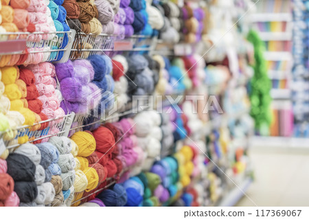 Blurred abstract background of store with assortment of knitting yarn. Skeins of yarn in store. Hobbies, needlework Blurred abstract background of store with assortment of knitting yarn. Skeins of yarn in store. Hobbies, needlework 117369067