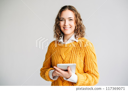 Smiling Young Professional with Digital Tablet. A cheerful businesswoman or student, holding a 117369071