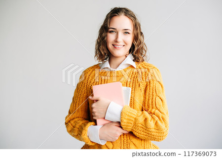Smiling Woman Holding Digital Tablet. Happy young woman holding a digital tablet, standing against a Smiling Woman Holding Digital Tablet. Happy young woman holding a digital tablet, standing against a 117369073