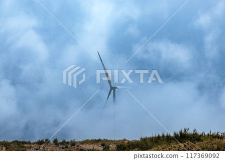 A wind turbine on the tops of mountains shrouded in fog on the island of Madeira 117369092