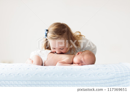 Child watching newborn baby in bassinet. Child watching newborn baby in bassinet. 117369651
