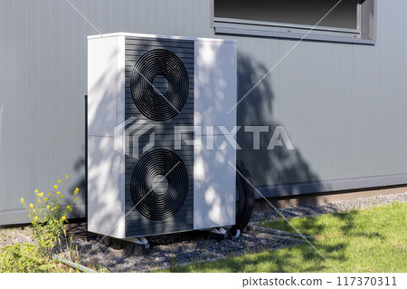 Heat pump unit installed outside a modern building Heat pump unit installed outside a modern building 117370311