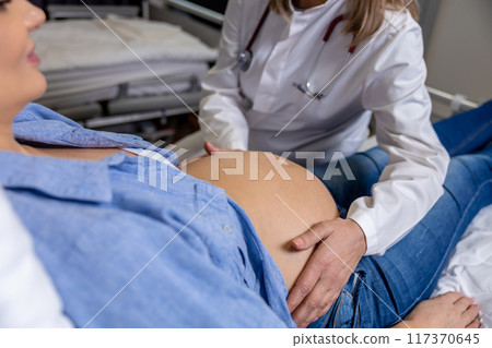 Doctor examining a pregnant woman on third trimester Doctor examining a pregnant woman on third trimester 117370645