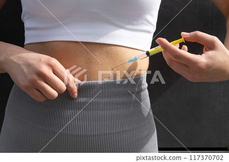 Close up of a woman doing lipolytic injection to her abs 117370702