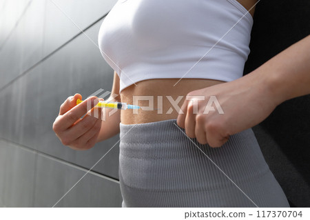 Close up of a woman doing lipolytic injection to her abs 117370704