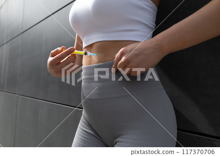Close up of a woman doing lipolytic injection to her abs 117370706