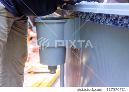 Cleaning of pool surface from dirt, trash debris with pool skimmer basket installed on frame that collects dirt trash 117370781